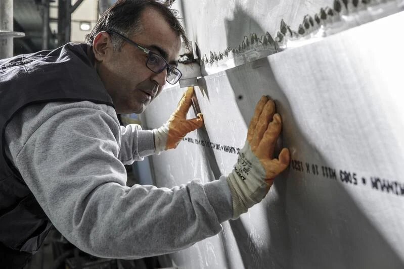 a man painting a white sheet aboard NEWAL Yacht for Sale