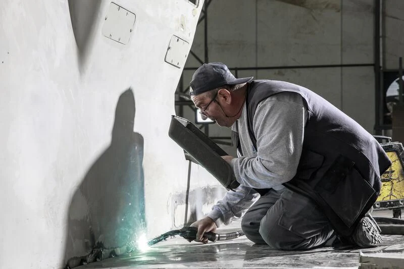 a man working on a laptop aboard NEWAL Yacht for Sale