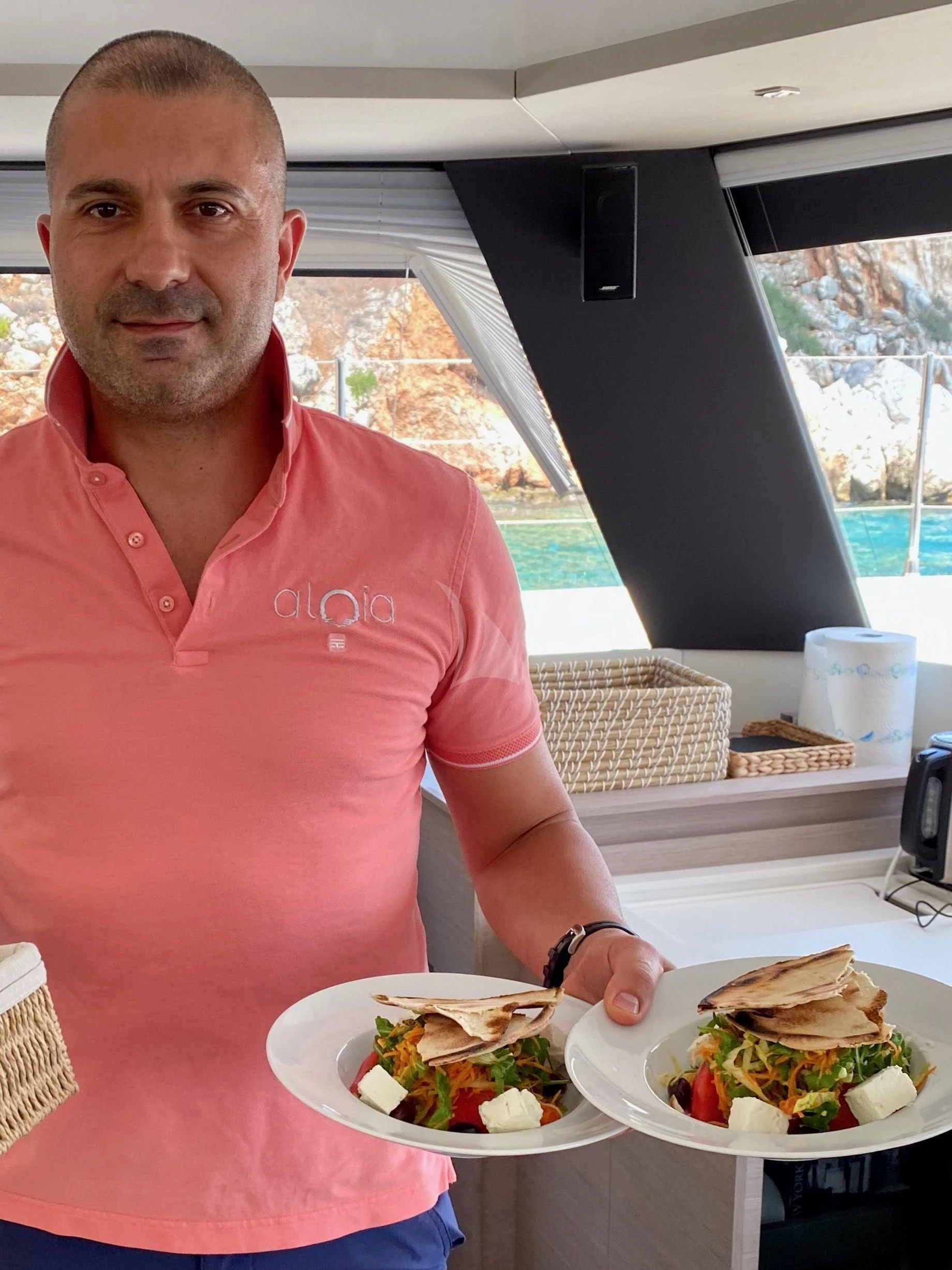 Marco Branca holding a plate of food aboard ALOIA Yacht for Charter
