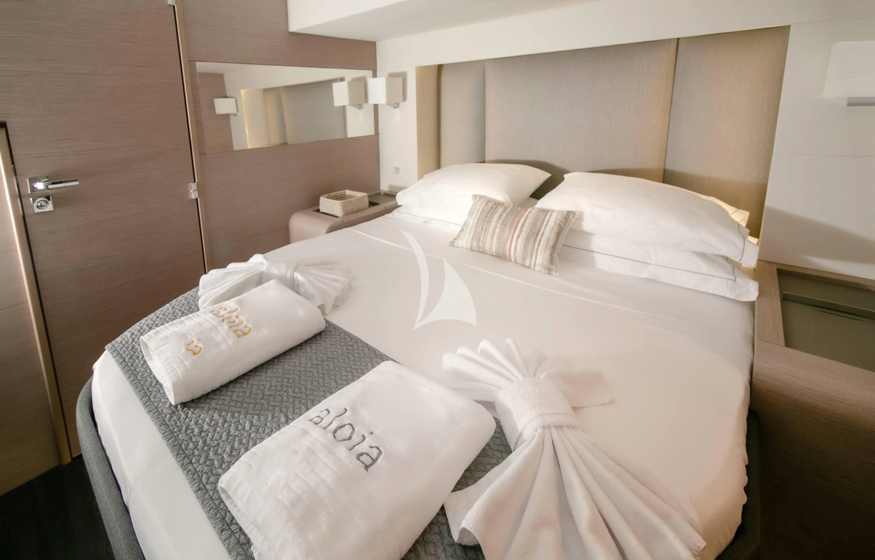 a bed with white sheets and pillows aboard ALOIA Yacht for Charter
