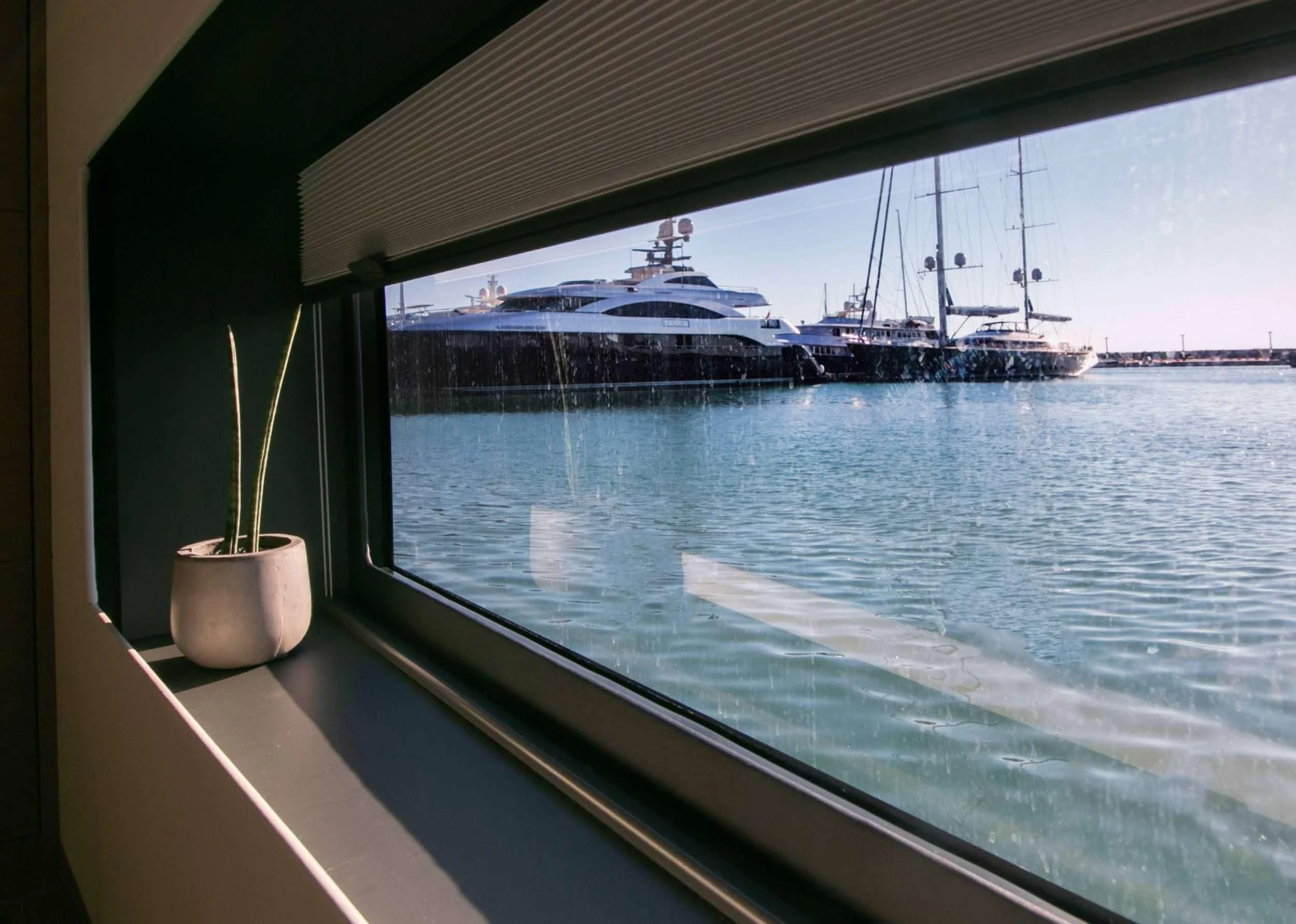 a view of a ship from a window of a boat on the water aboard ALOIA Yacht for Charter