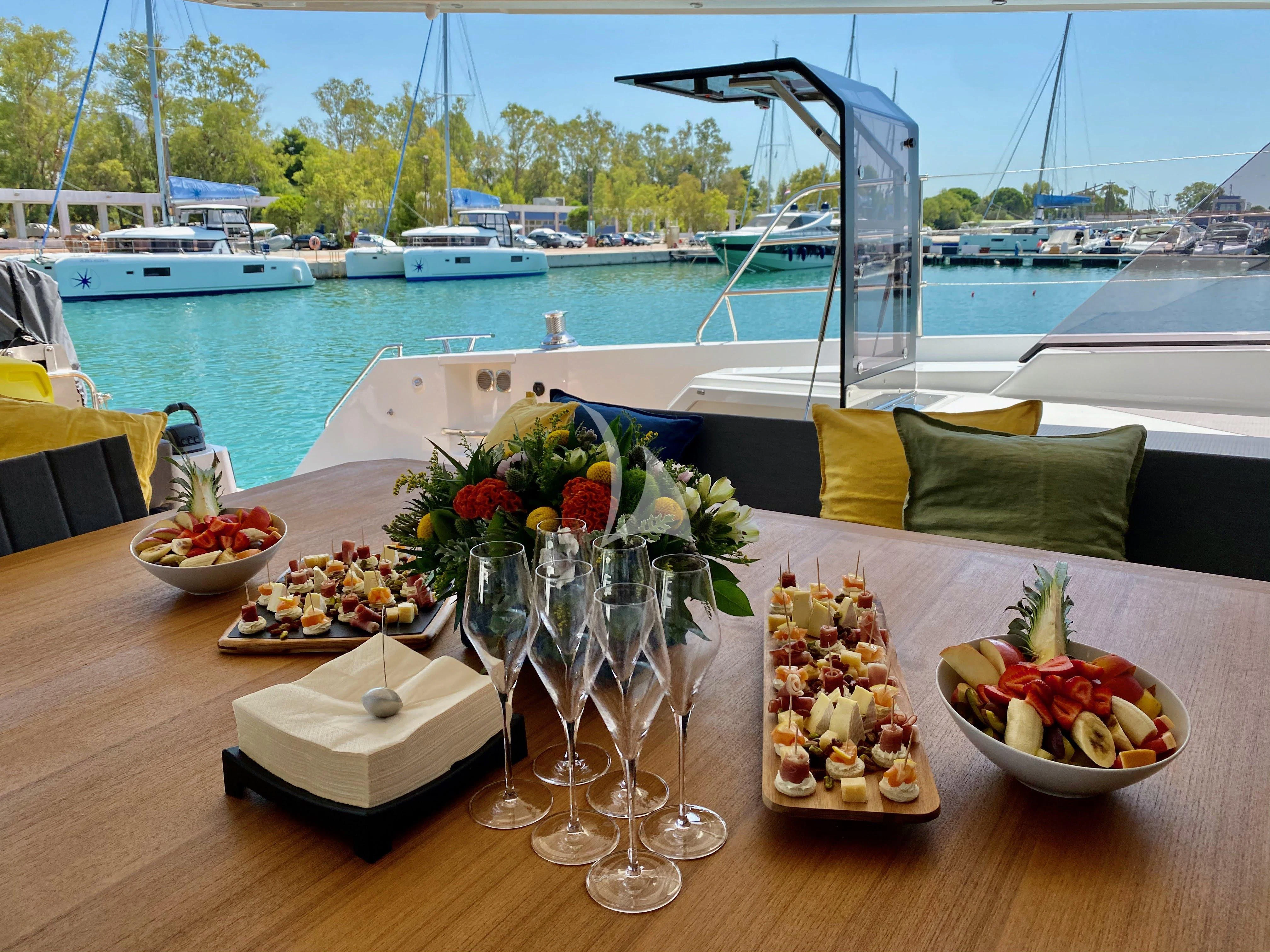 a table with food and glasses on it aboard ALOIA Yacht for Charter