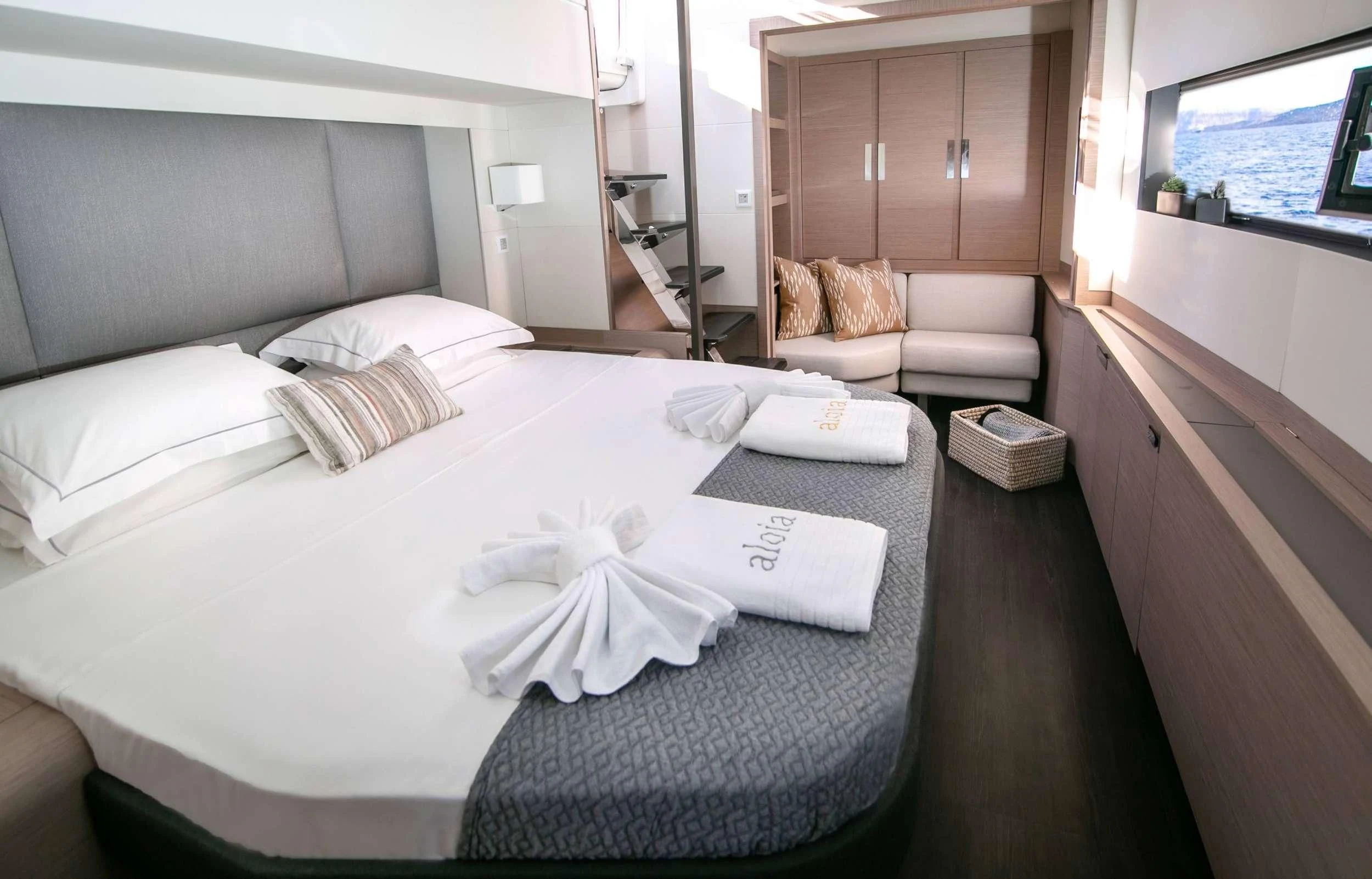 a bed with a white sheet and pillows on it aboard ALOIA Yacht for Charter