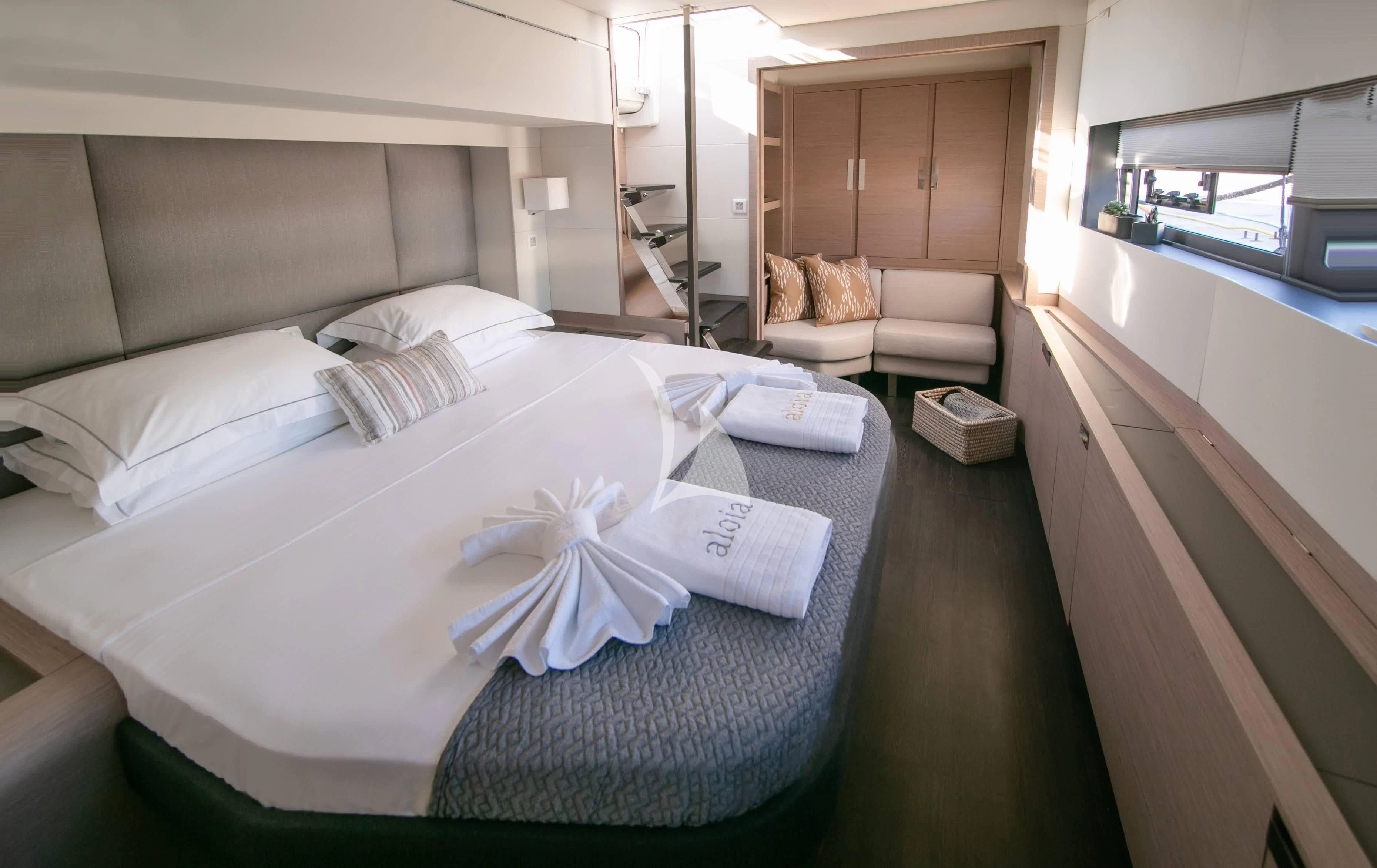 a bed with a white sheet and pillows on it aboard ALOIA Yacht for Charter