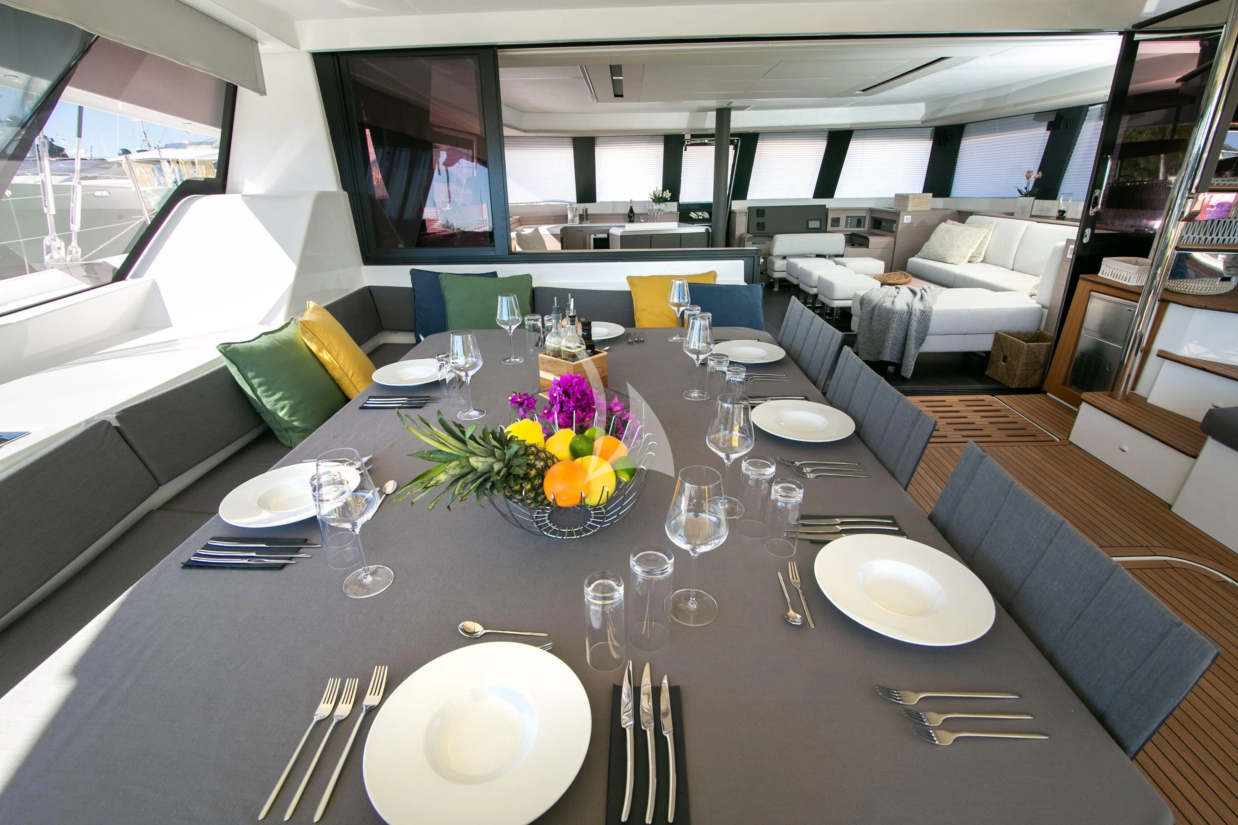 a table set with place settings aboard ALOIA Yacht for Charter
