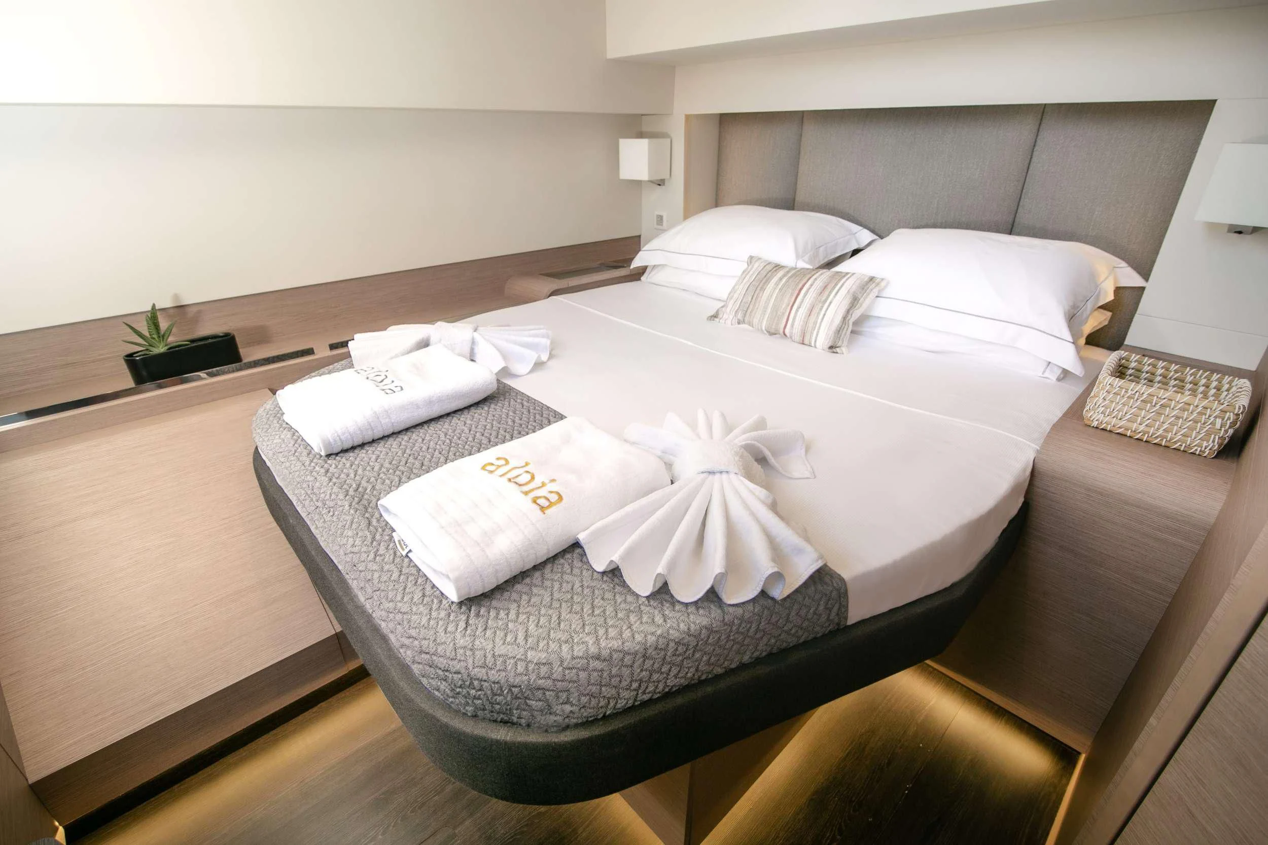 a bed with a white sheet and pillows on it aboard ALOIA Yacht for Charter