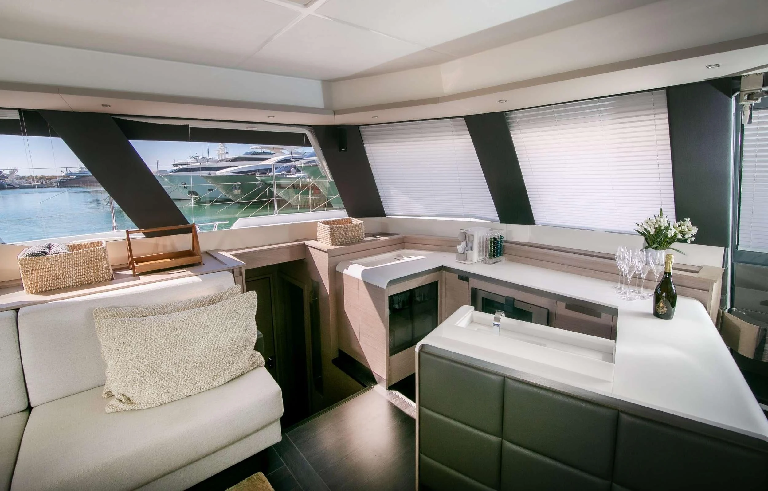 a room with a couch and a table with a vase of flowers aboard ALOIA Yacht for Charter
