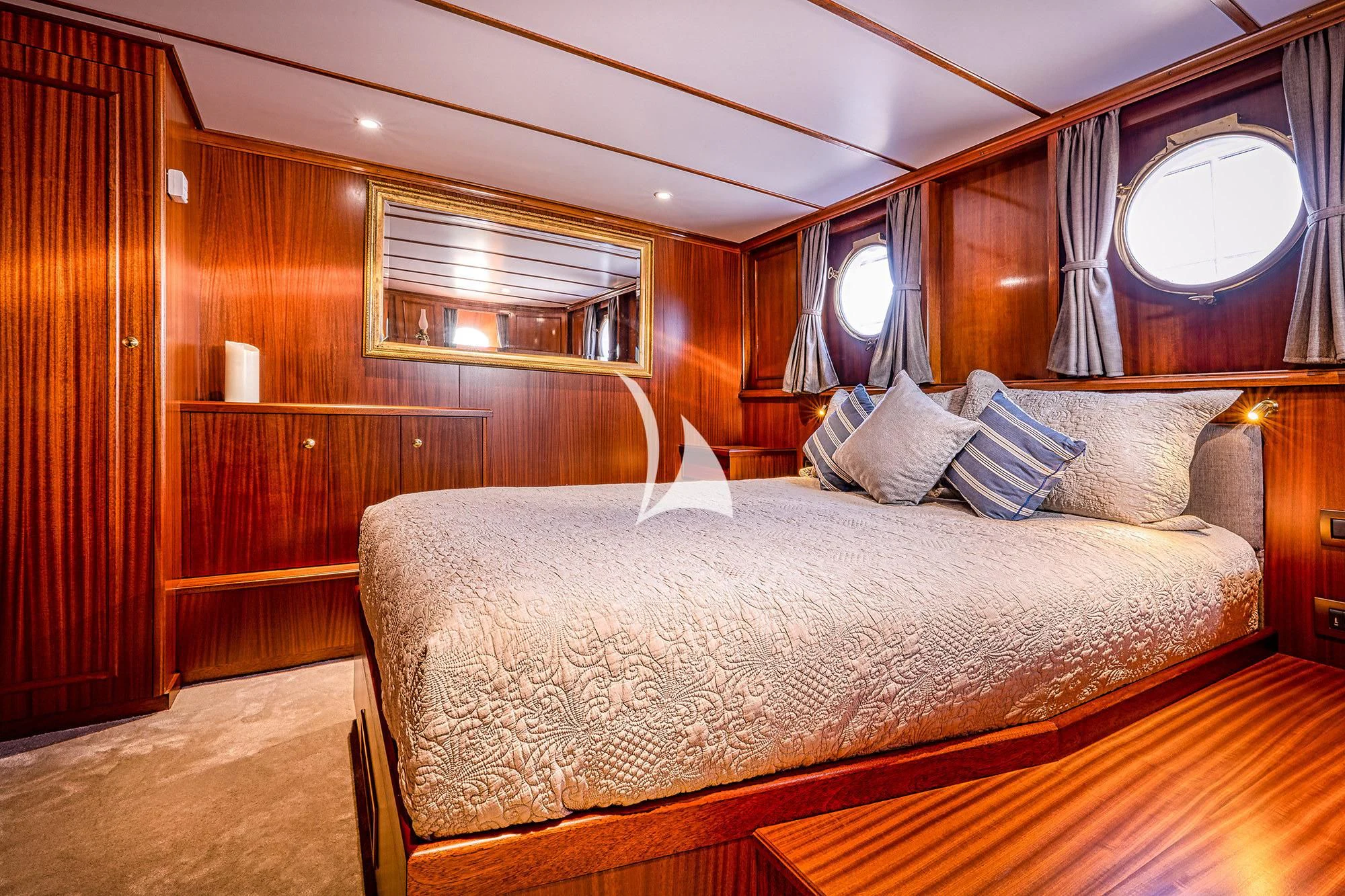 a bed with a large mirror above it aboard CHANTELLA Yacht for Sale