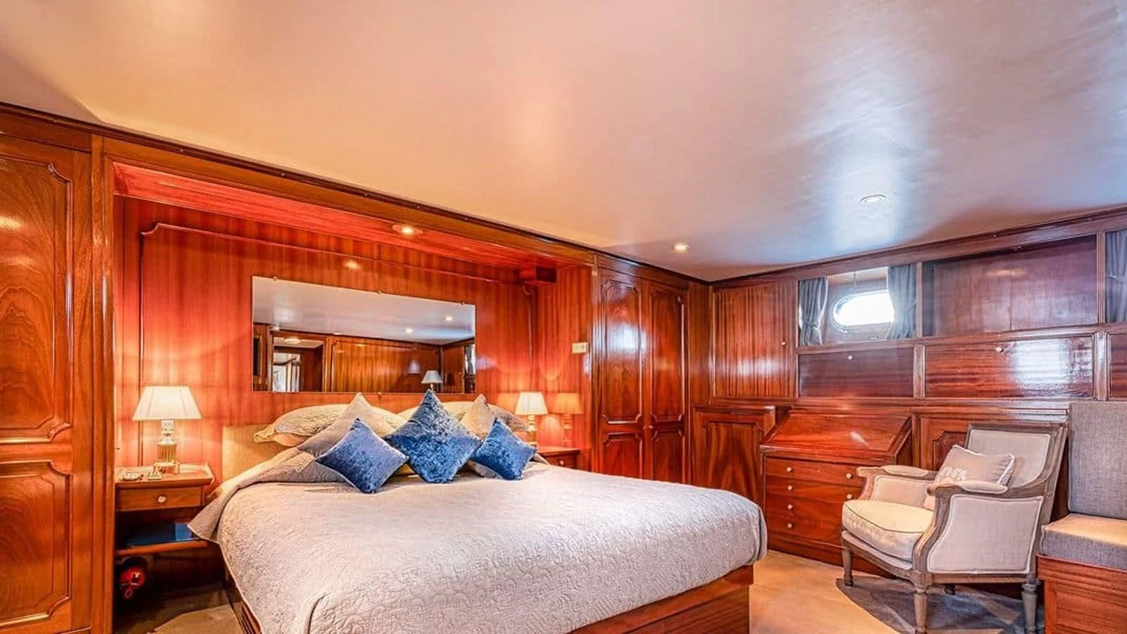 a bedroom with a bed and a chair aboard CHANTELLA Yacht for Sale