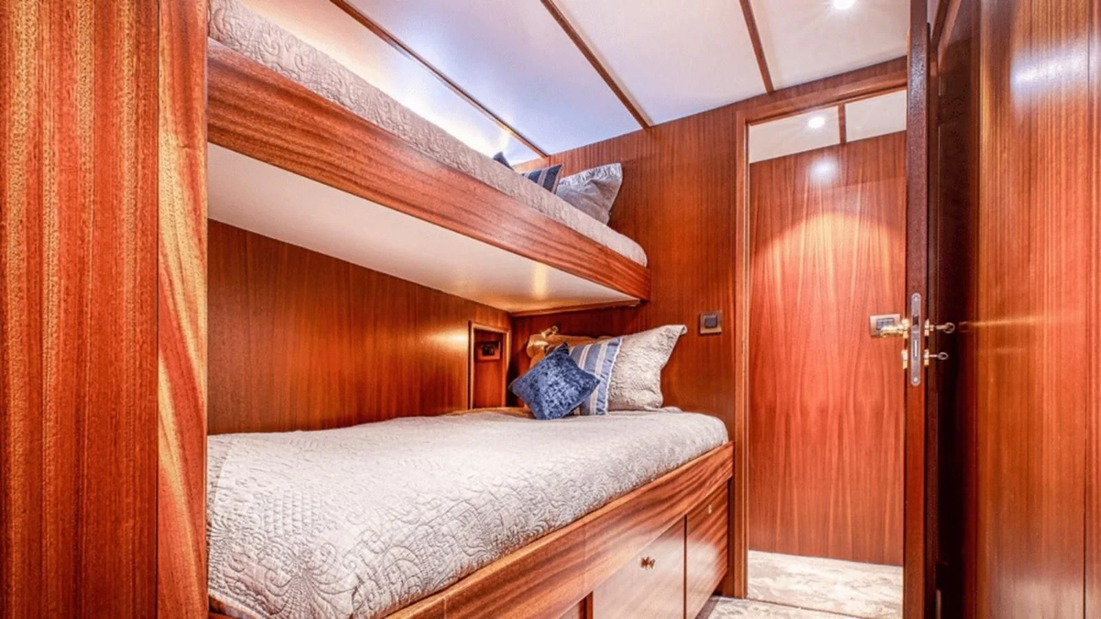 a bedroom with a bed and a wood door aboard CHANTELLA Yacht for Sale