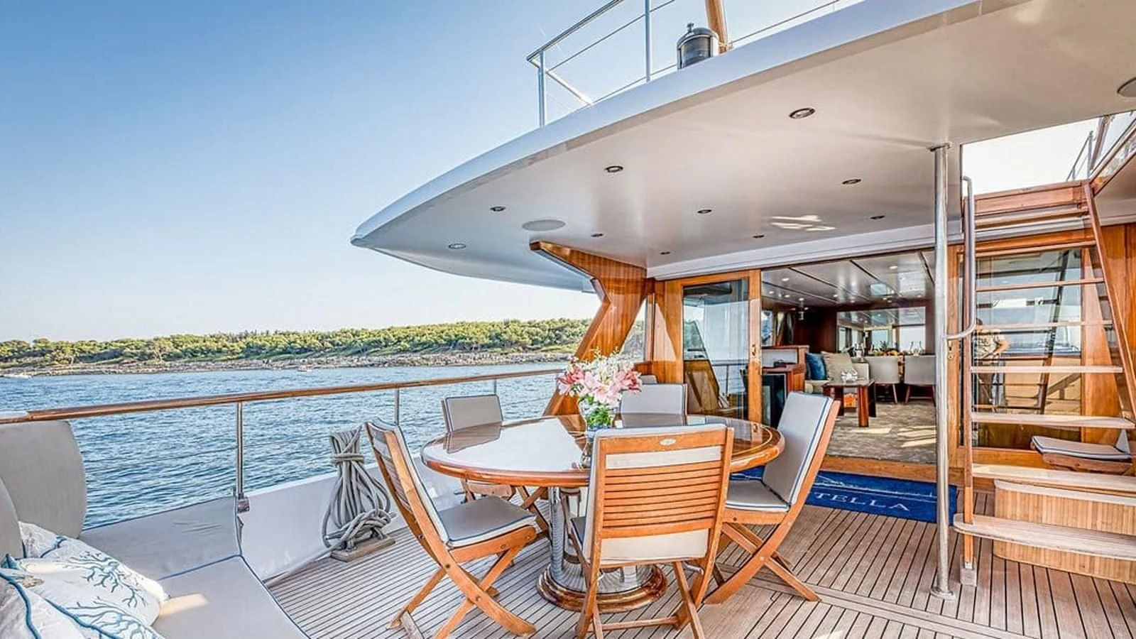 a deck with a table and chairs on it aboard CHANTELLA Yacht for Sale
