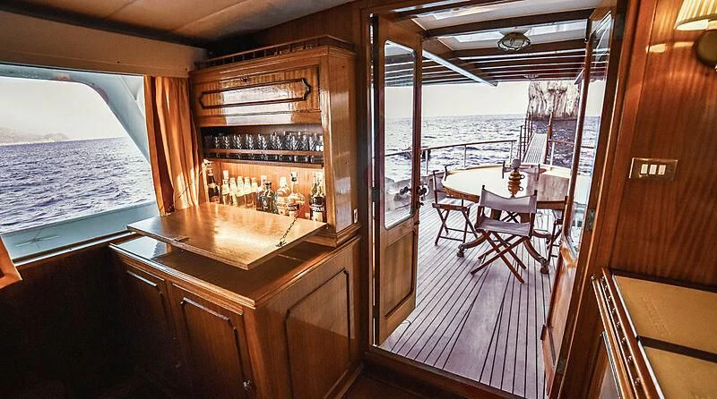 a bar with a bar and a table and chairs aboard ENTRANCER Yacht for Sale