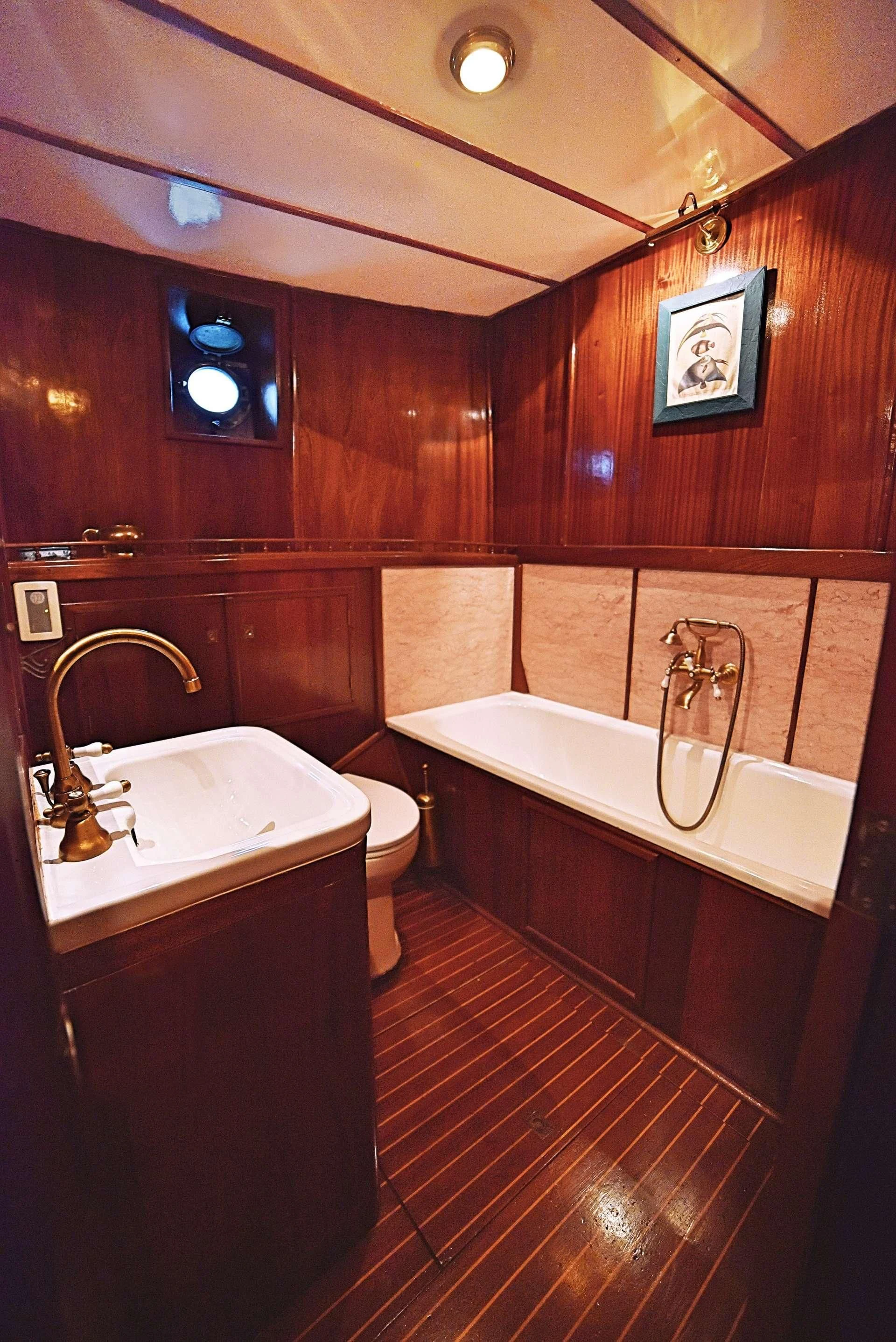a bathroom with a tub sink and toilet aboard ENTRANCER Yacht for Sale