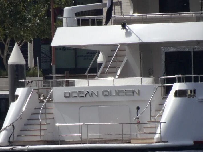 a white boat with a sign on it aboard OCEAN QUEEN Yacht for Sale