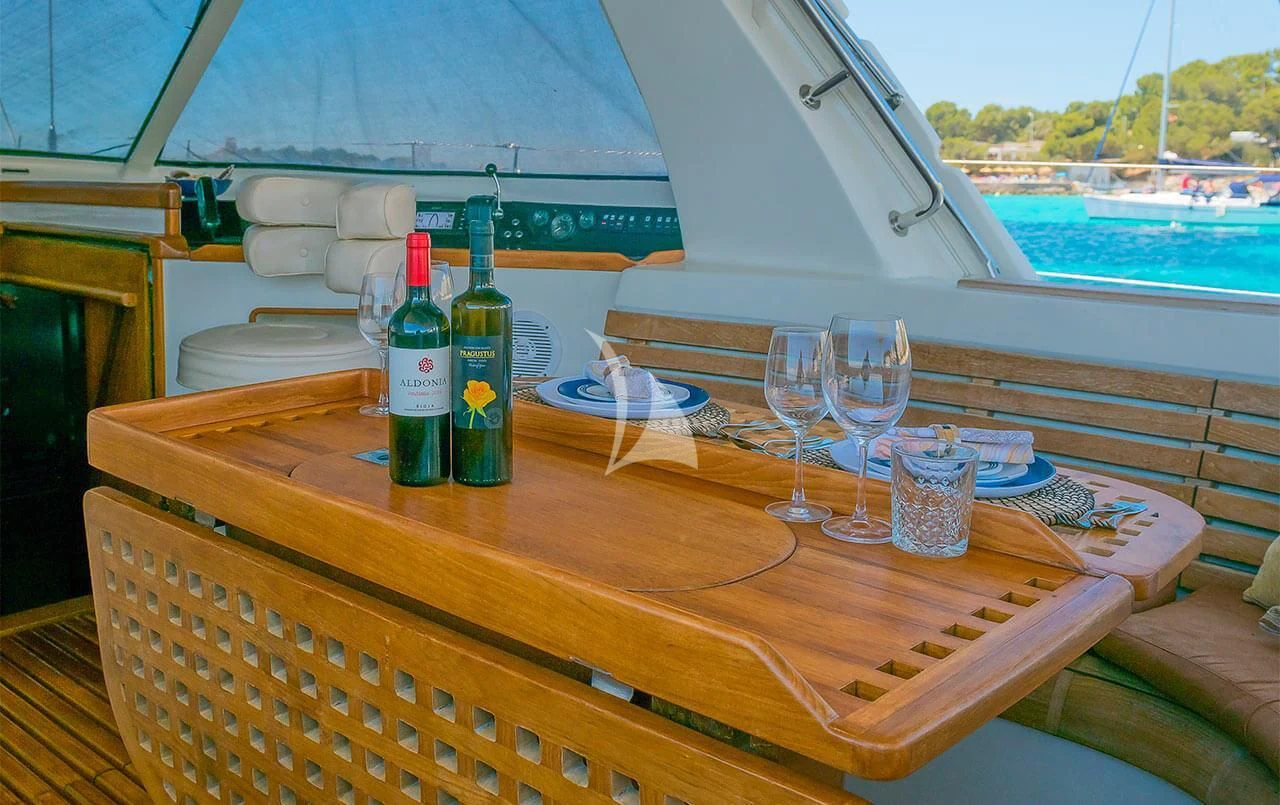 a table with wine bottles and glasses on it aboard OCEAN PHOENIX Yacht for Sale