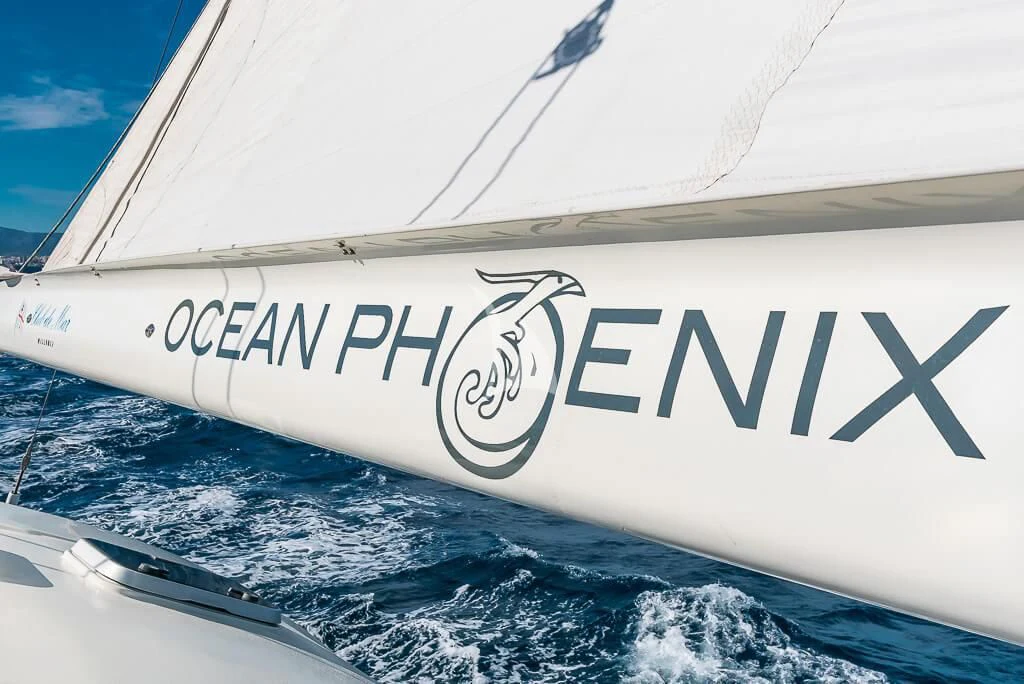 a white boat with a logo on the front aboard OCEAN PHOENIX Yacht for Sale