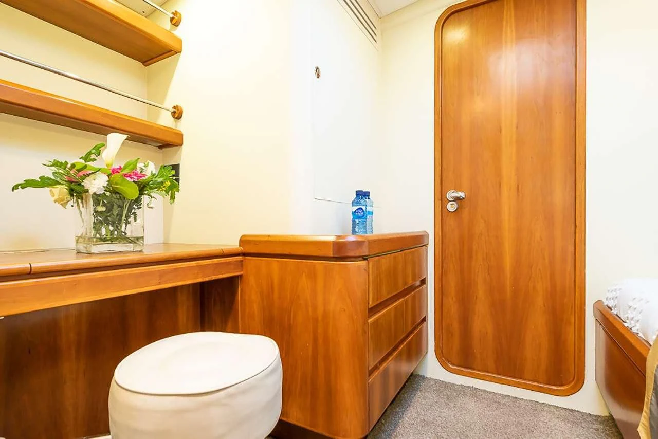 a bathroom with a toilet and a cabinet aboard OCEAN PHOENIX Yacht for Sale