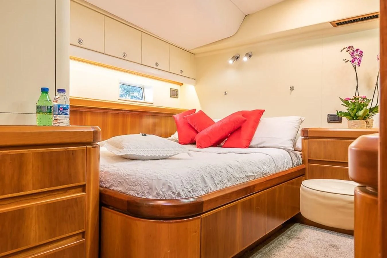 a bed with red pillows aboard OCEAN PHOENIX Yacht for Sale