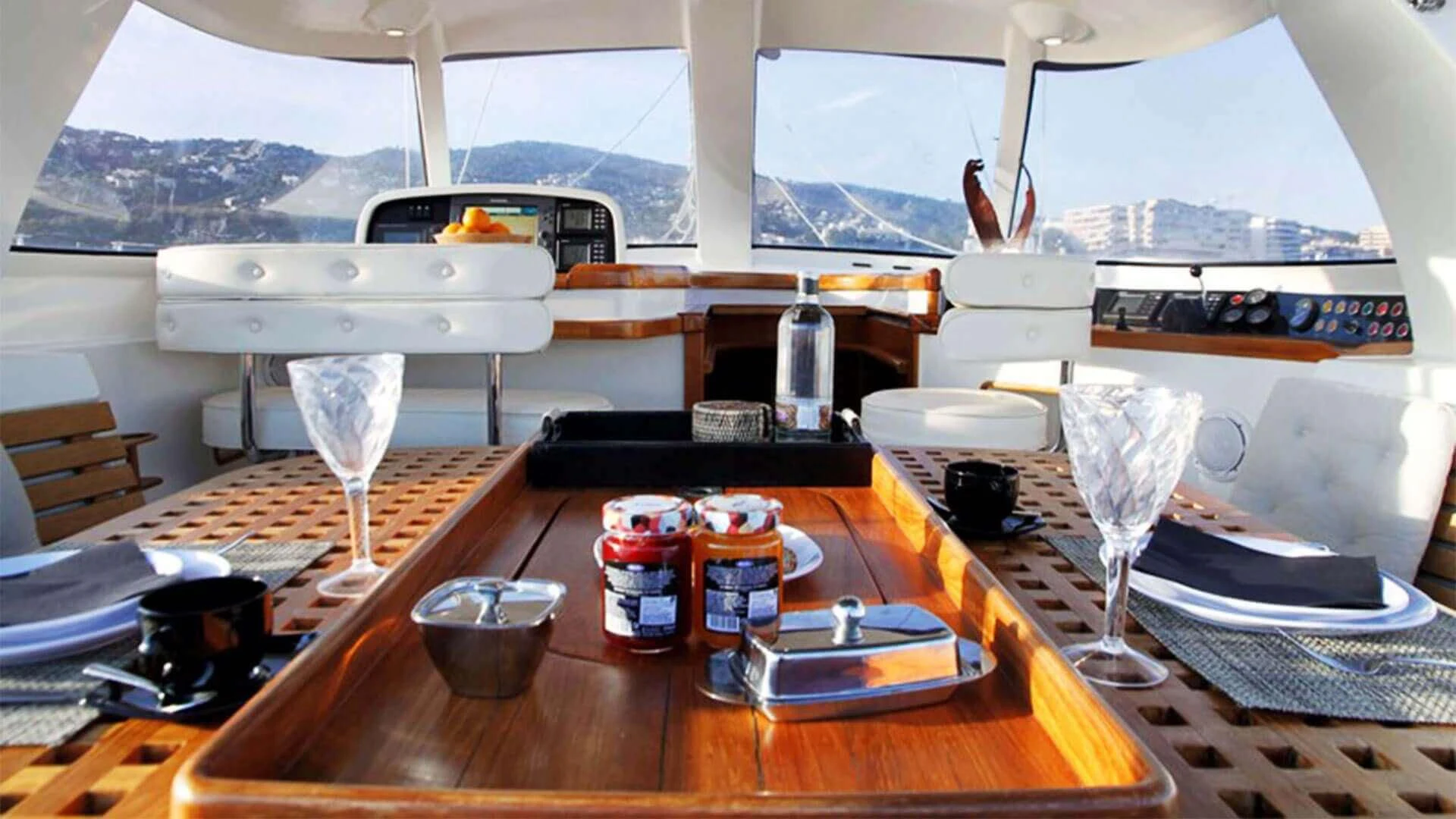 a table with a wine glass and a bottle of wine on it aboard OCEAN PHOENIX Yacht for Sale