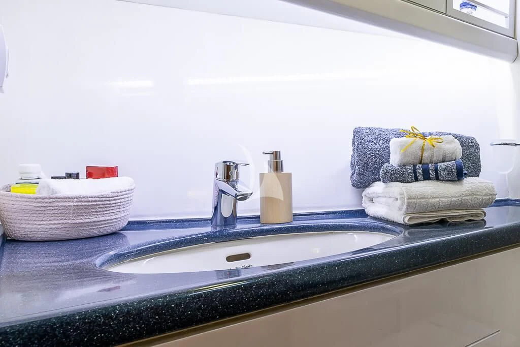a bathroom with towels and flowers aboard OCEAN PHOENIX Yacht for Sale