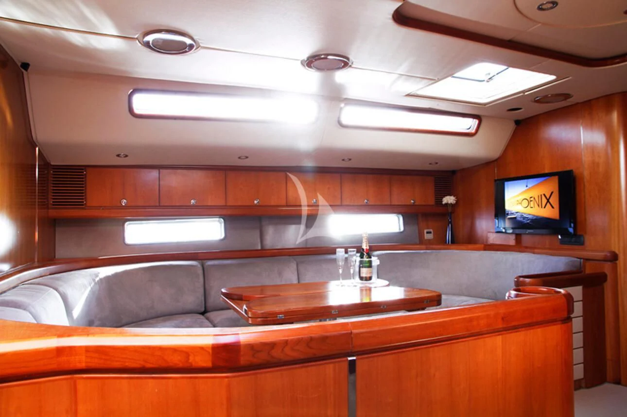 a room with a tv and a table aboard OCEAN PHOENIX Yacht for Sale