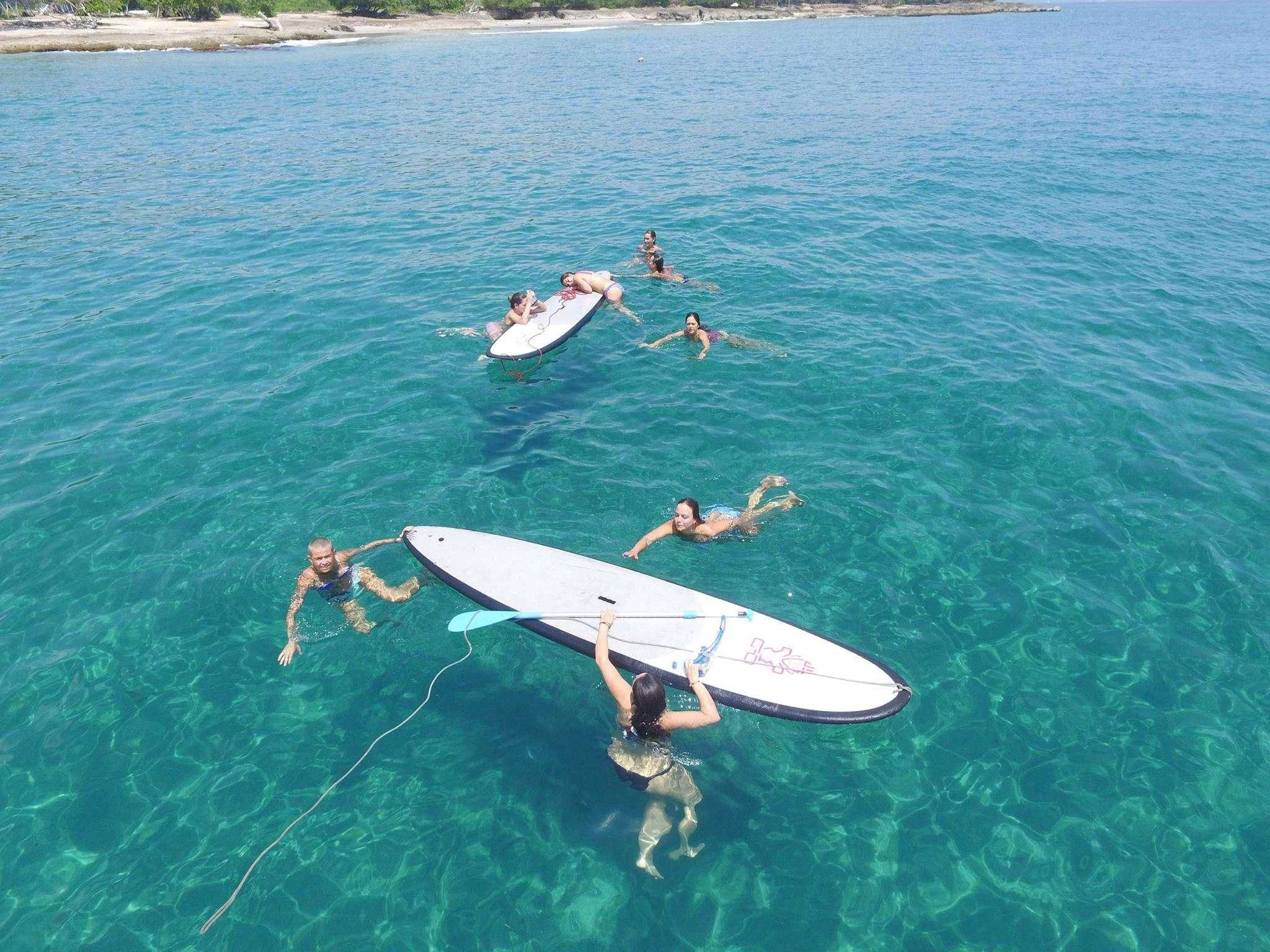 a group of people on surfboards in the water aboard OCEAN PHOENIX Yacht for Sale