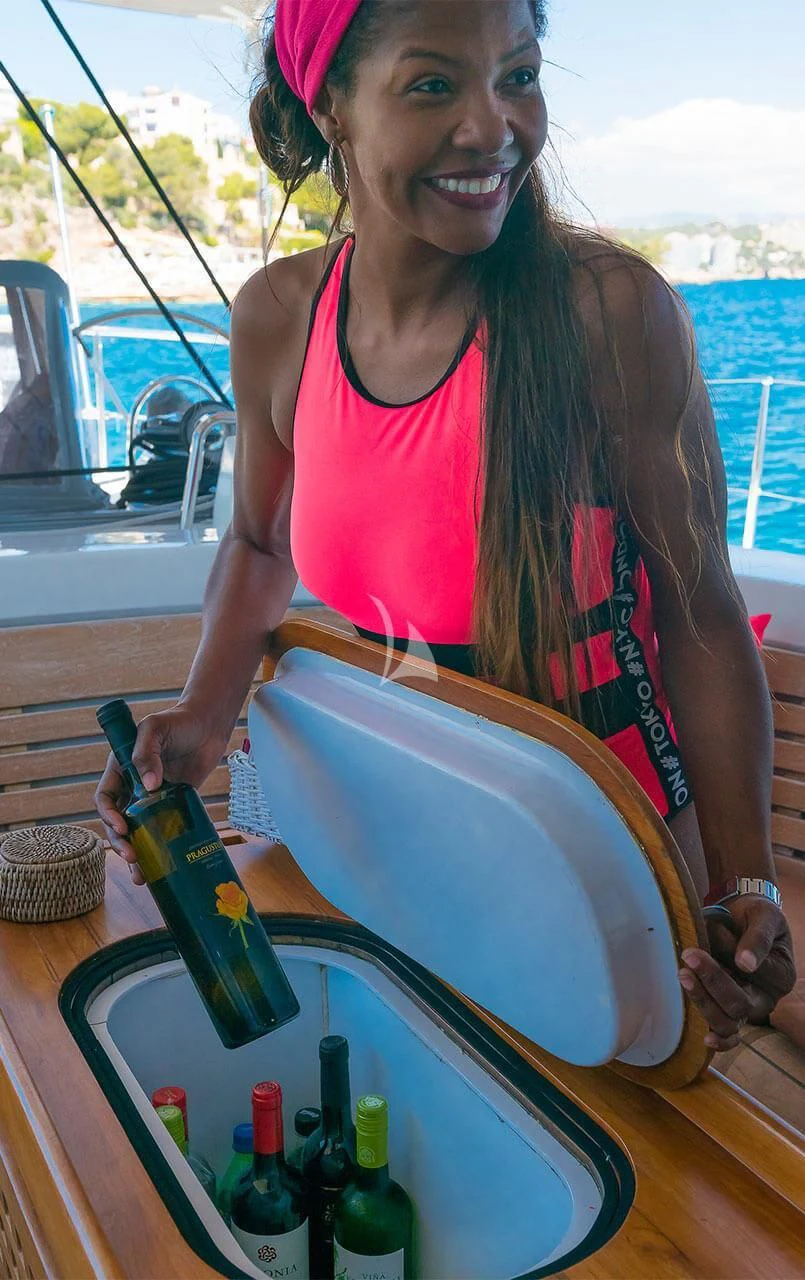 Simone holding a bottle of beer aboard OCEAN PHOENIX Yacht for Sale