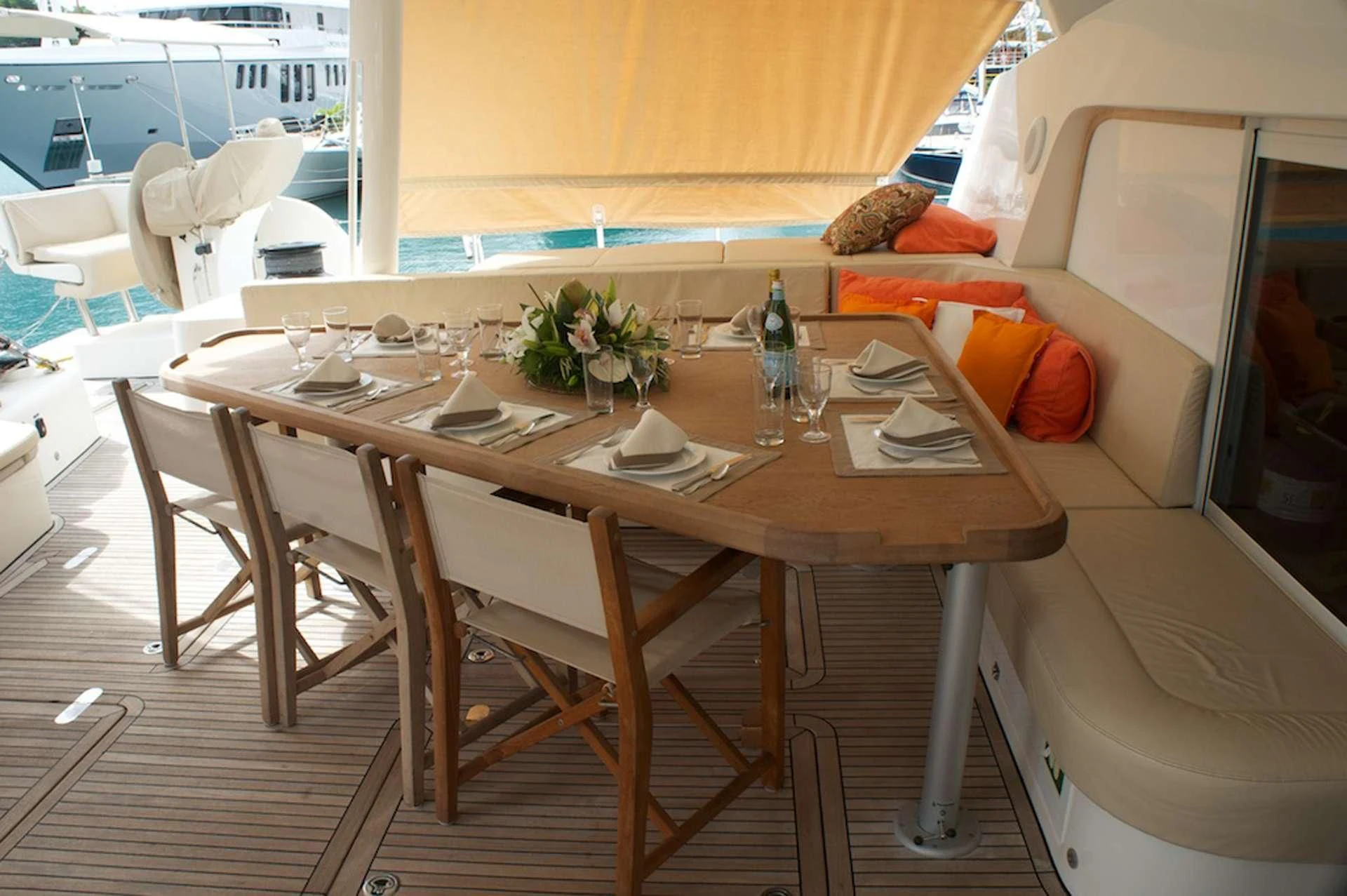a table with chairs and a vase of flowers on it aboard OCEAN PHOENIX Yacht for Sale