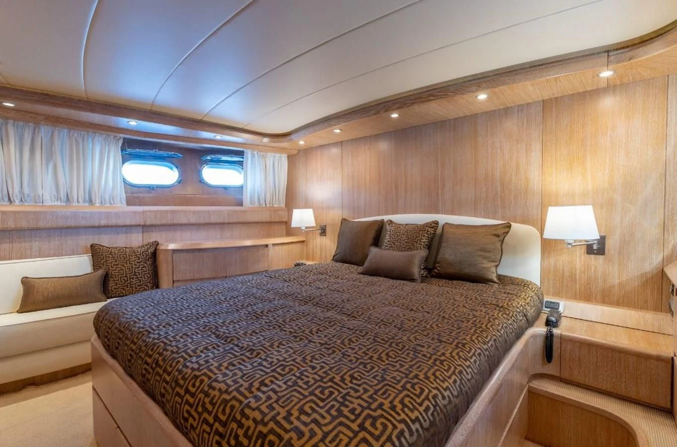 a bed with a couch and a window aboard COOKIE Yacht for Charter