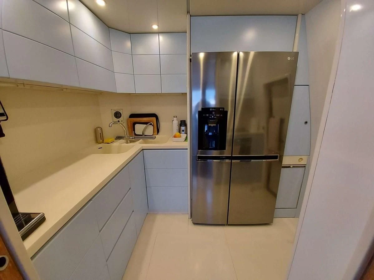 a kitchen with a stainless steel refrigerator aboard COOKIE Yacht for Charter