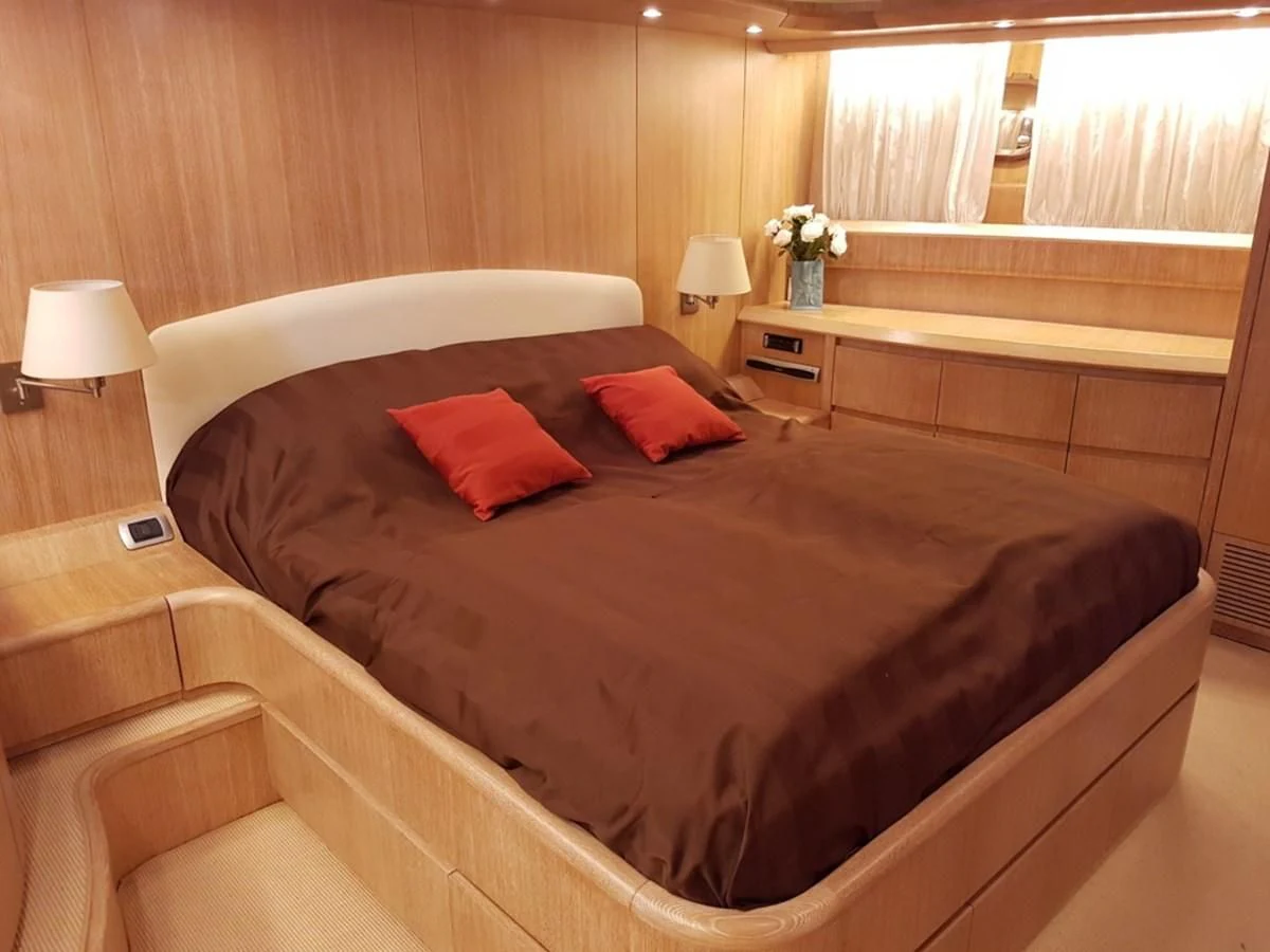a bed with red pillows aboard COOKIE Yacht for Charter
