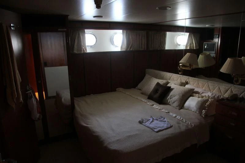 a bed with a white bed spread aboard SEAGULL OF CAYMAN Yacht for Sale