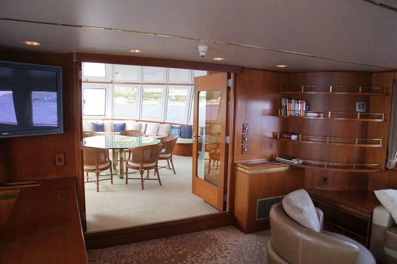 a room with a wood shelf and a table and chairs aboard SEAGULL OF CAYMAN Yacht for Sale
