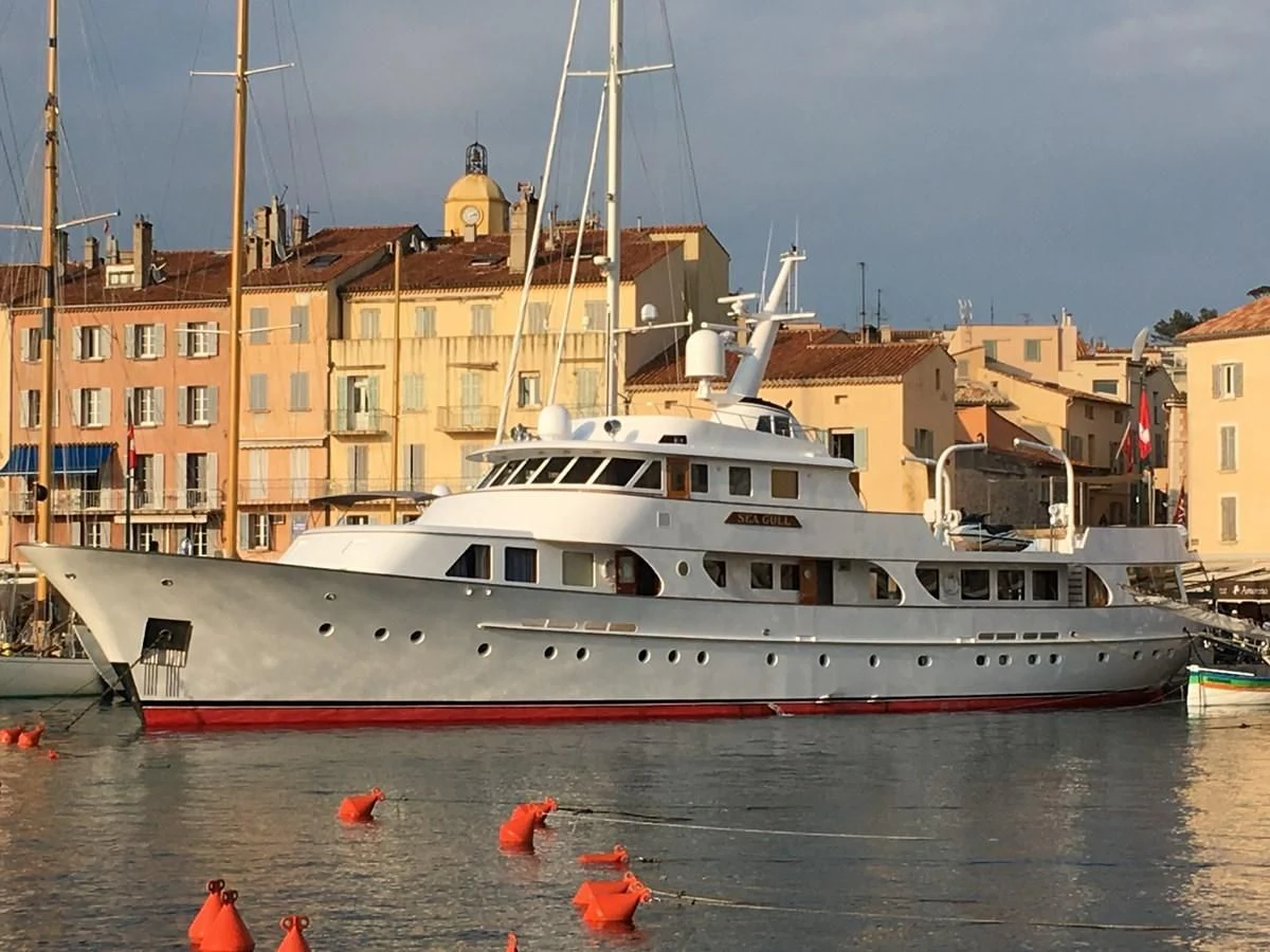 a large white boat in a harbor aboard SEAGULL OF CAYMAN Yacht for Sale