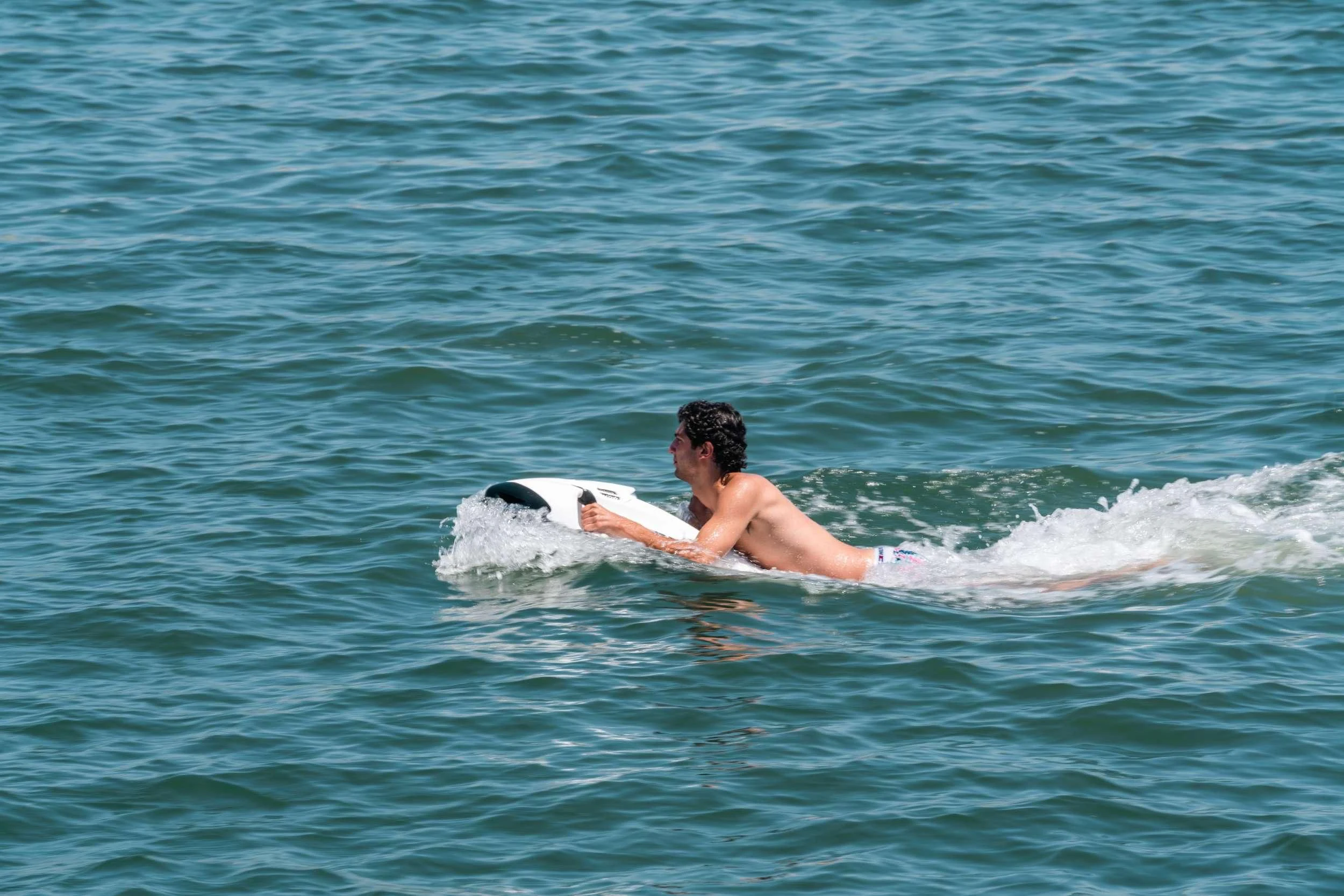 a person surfing on the waves aboard MAVE Yacht for Sale