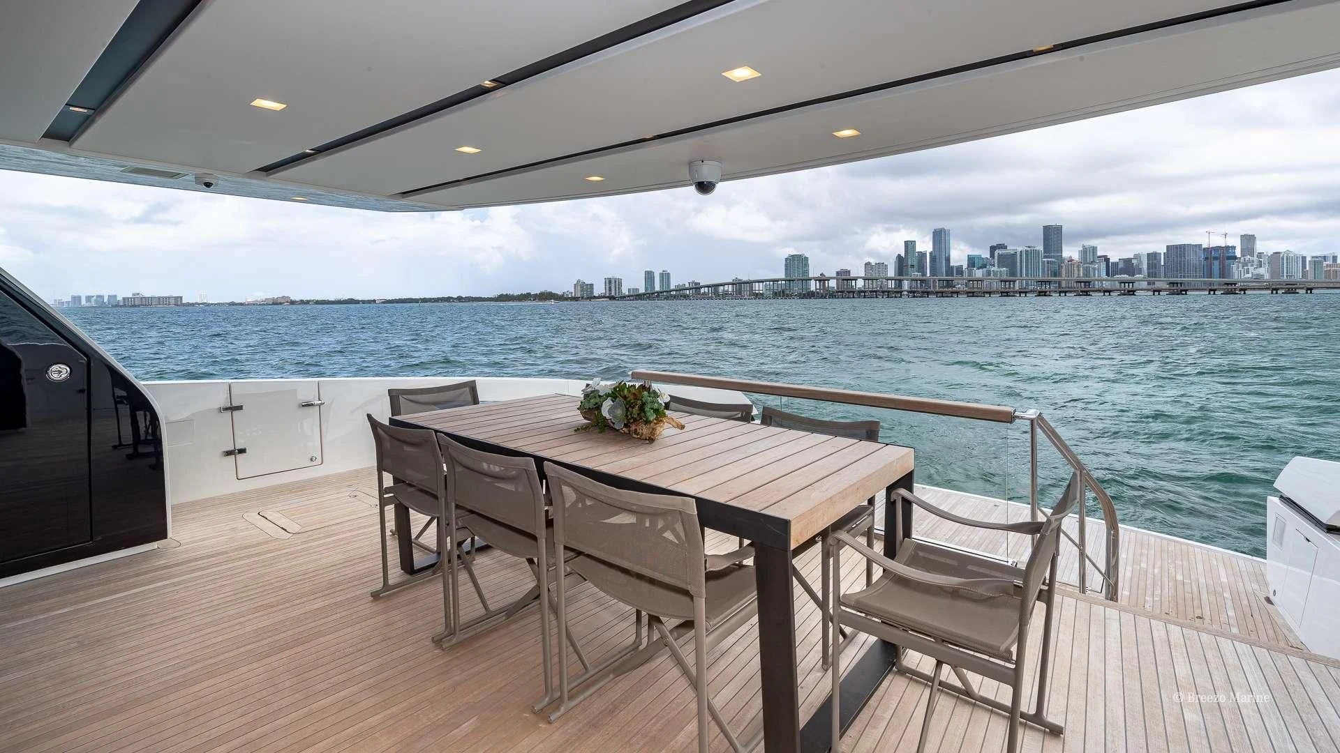 a table and chairs on a deck overlooking a city aboard MAVE Yacht for Sale