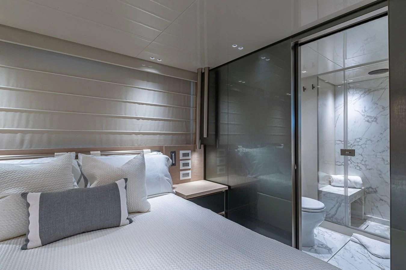 a bed next to a glass door aboard MAVE Yacht for Sale