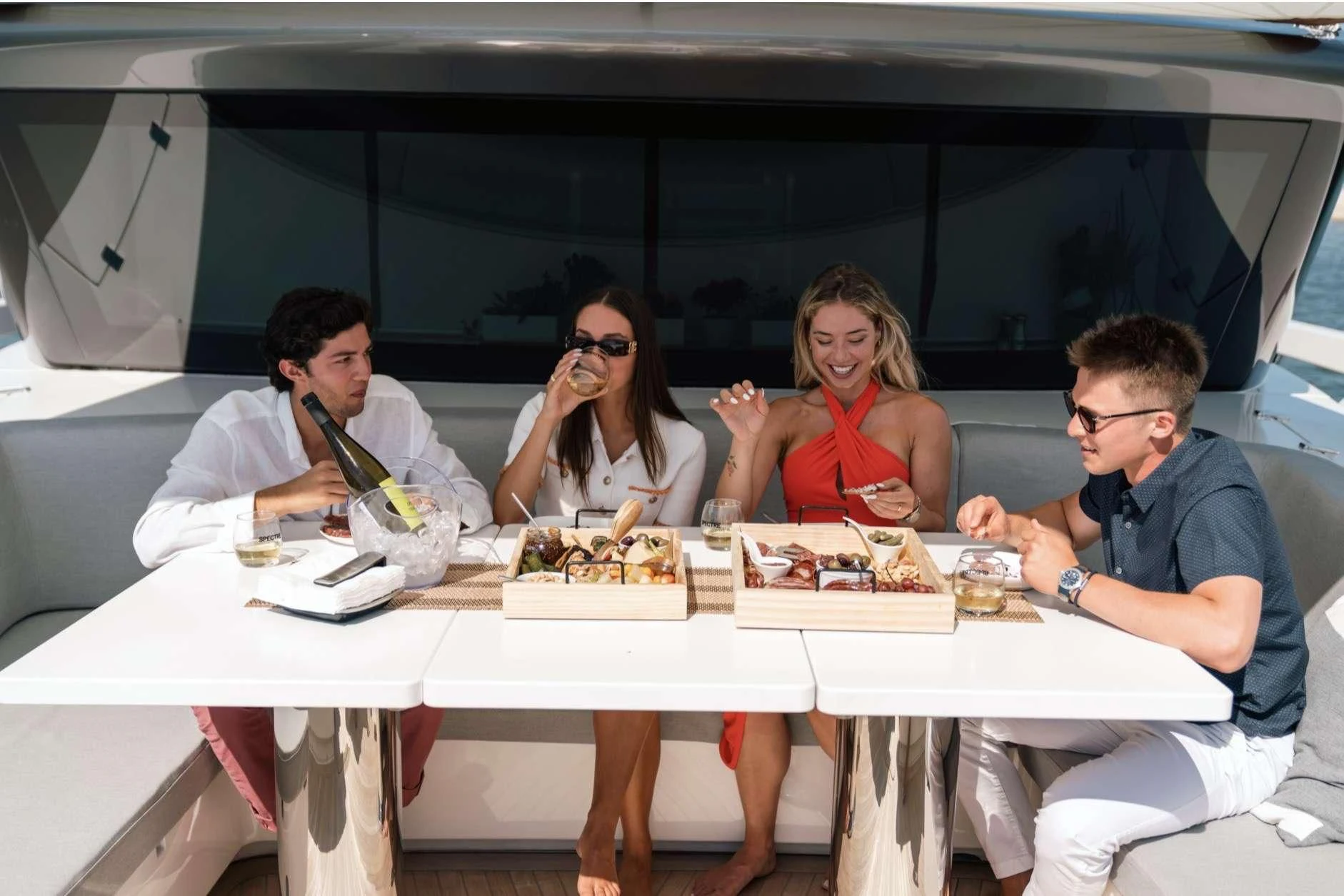 a group of people sitting at a table with food aboard MAVE Yacht for Sale