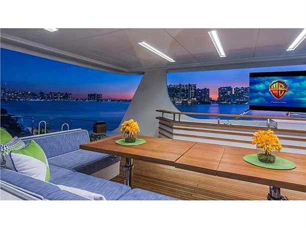 a room with a view of a large pool and a television aboard PRIMA MEA Yacht for Sale
