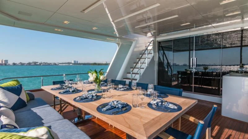 a large room with a table and chairs and a view of the water aboard PRIMA MEA Yacht for Sale