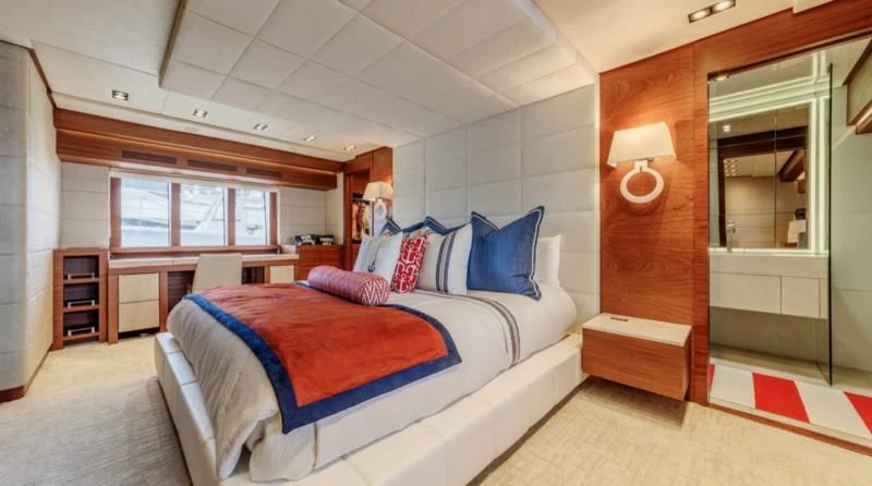 a bedroom with a bed and a mirror aboard PRIMA MEA Yacht for Sale
