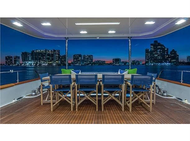 a deck with tables and chairs aboard PRIMA MEA Yacht for Sale