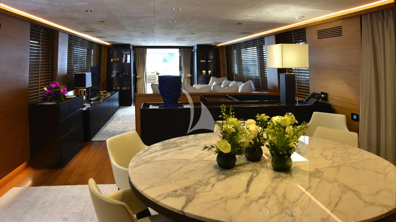 a large living room with a large table and chairs aboard XIPHIAS Yacht for Charter