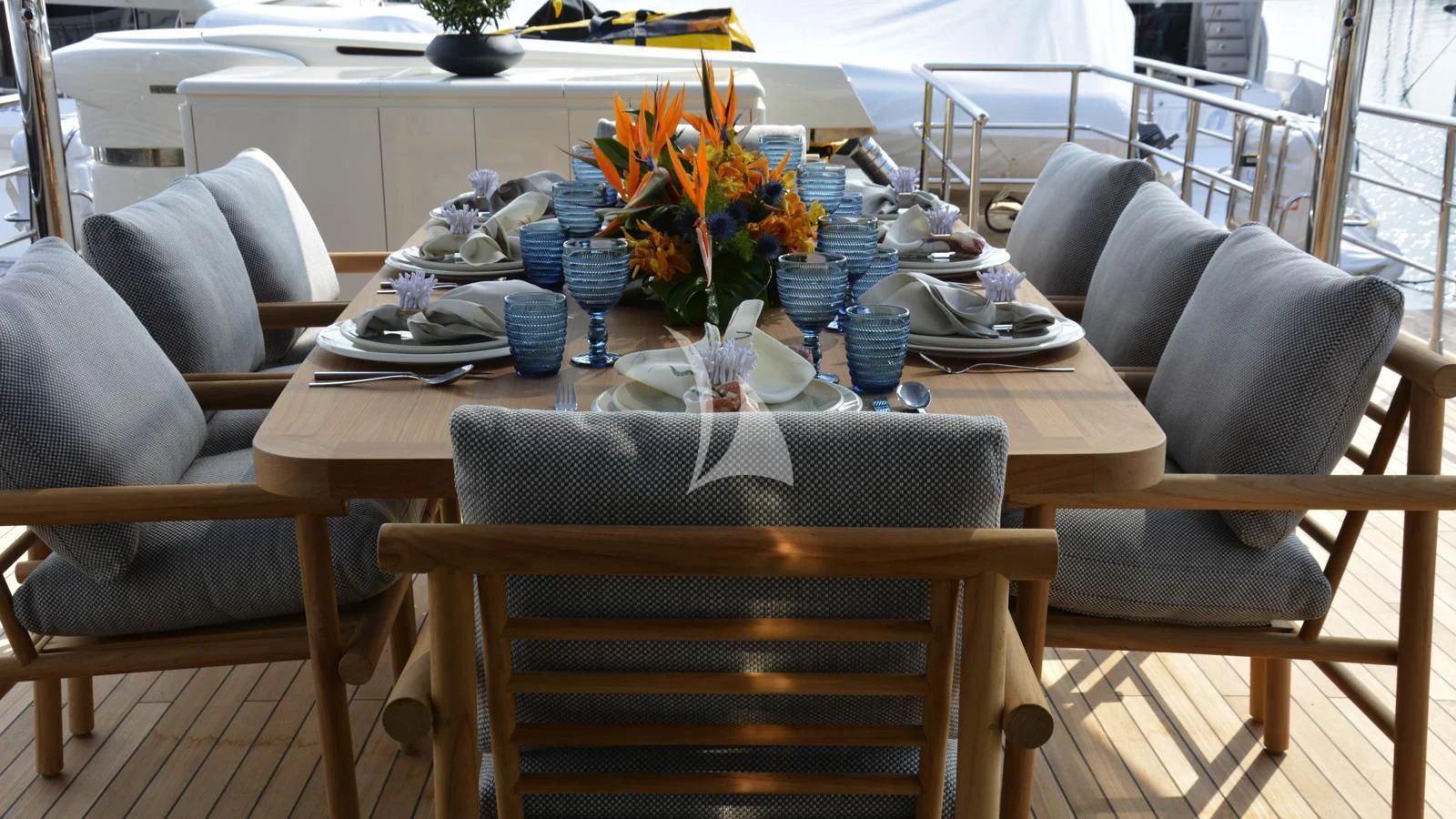 a table set with a flower vase and chairs aboard XIPHIAS Yacht for Charter