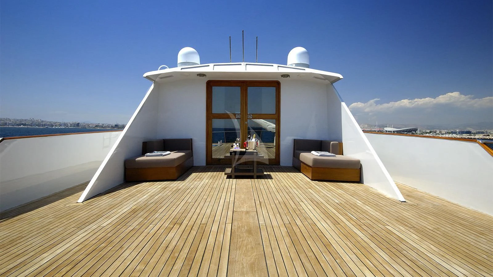 a room with a bed and a table on a deck aboard XIPHIAS Yacht for Charter