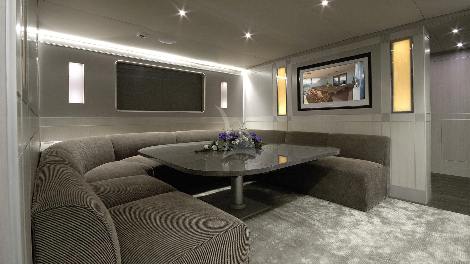 a living room with a large sofa and a tv aboard XIPHIAS Yacht for Charter