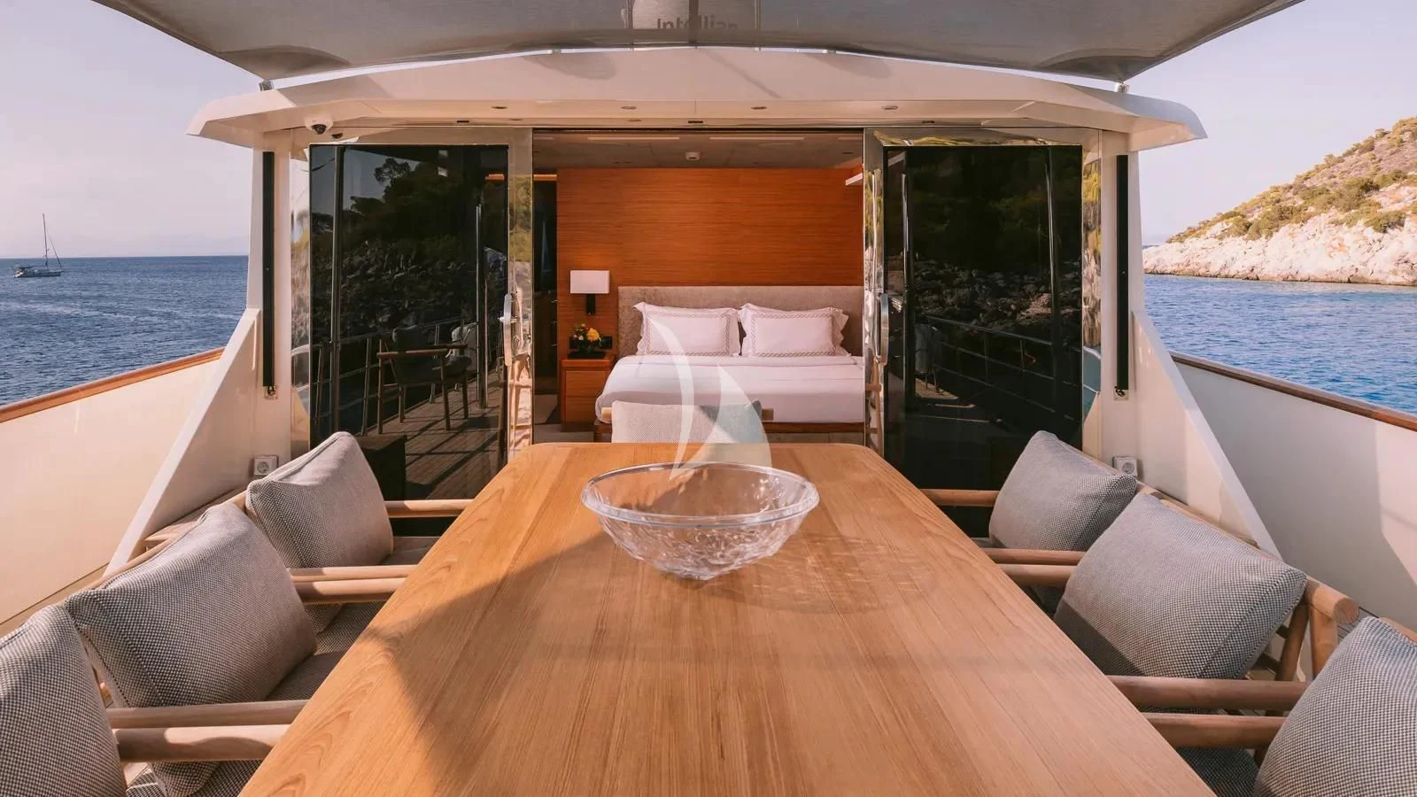 a table with chairs and a bed on it aboard XIPHIAS Yacht for Charter