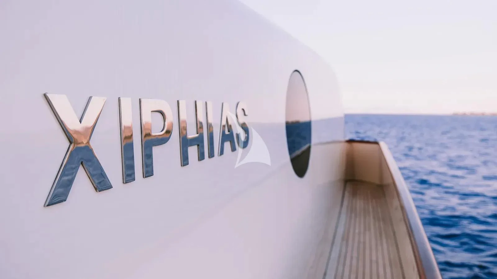 a hand holding a sign over a body of water aboard XIPHIAS Yacht for Charter