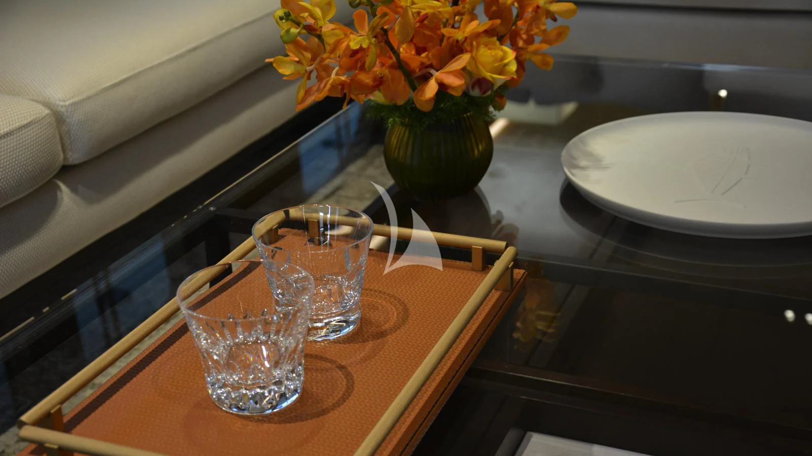 a glass of water and a vase with flowers on a table aboard XIPHIAS Yacht for Charter