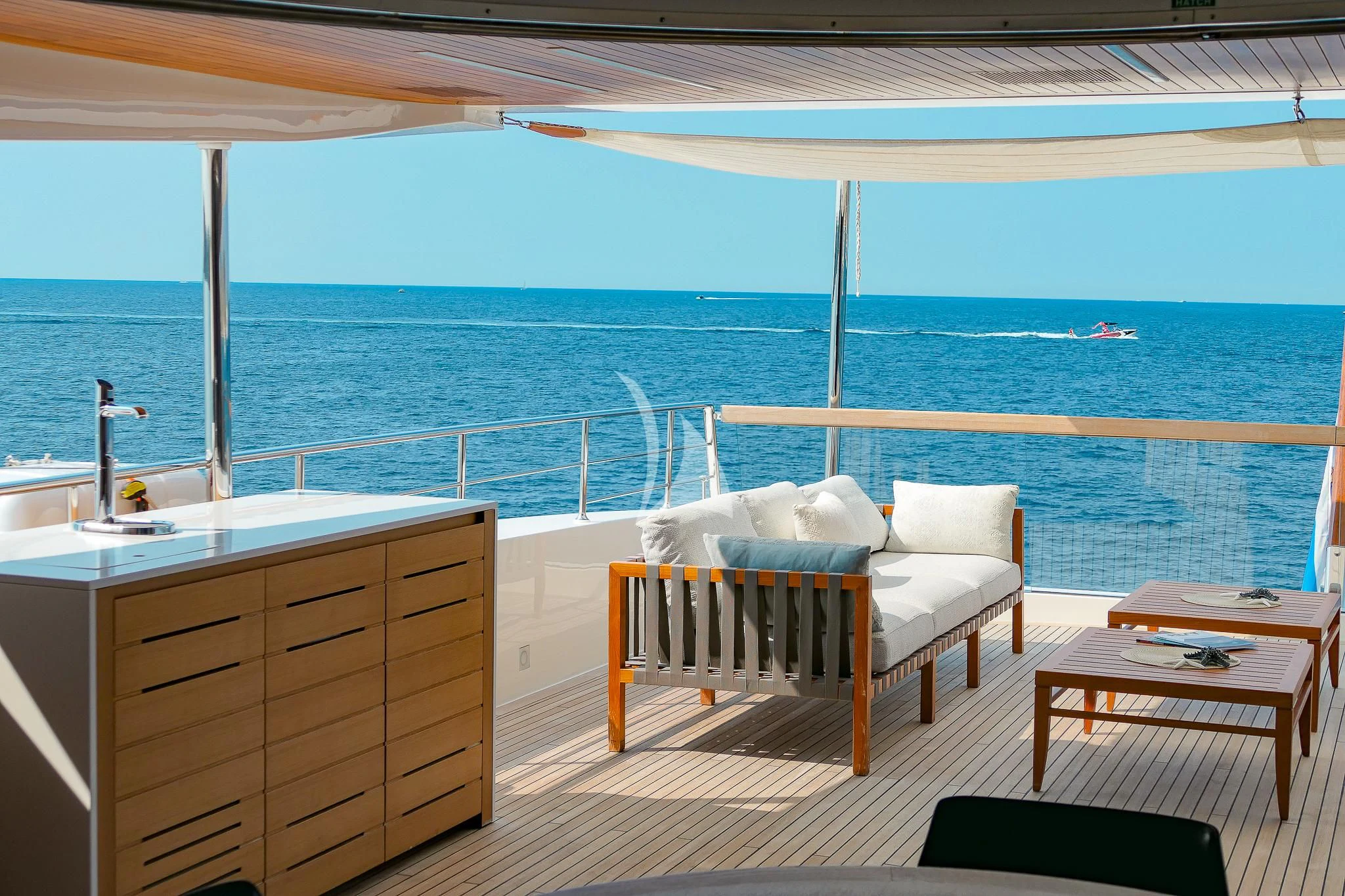 a room with a bed and a table and chairs on a deck aboard TINY WAVE Yacht for Sale